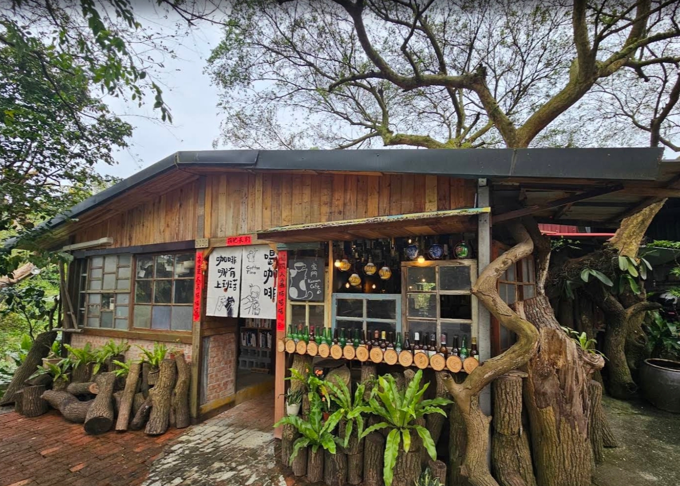 The rustic wooden Kamon Café beneath mature trees